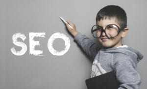 cute kid with a pointer at the word SEO