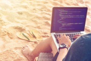 coder on the beach with laptop